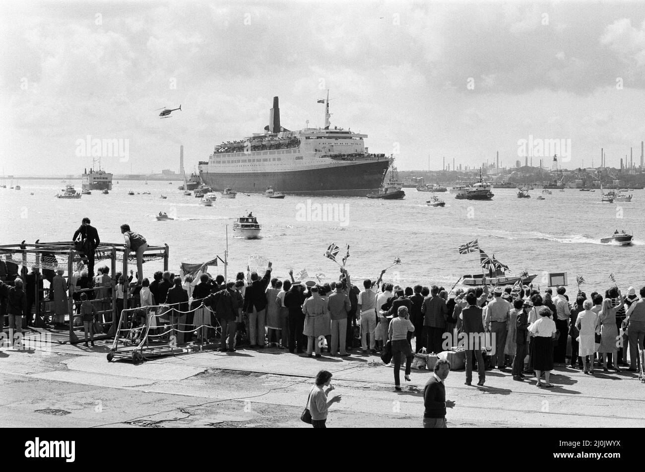 Il QE2 torna a casa a Southampton. Union Jacks è festooned sulle automobili, drappeggiato sulle spalle, ondulato sui bastoni. Southampton dà il benvenuto a "Three Cheers" al QE2 lussuoso liner trasformato in trooper di ritorno dalla guerra. A bordo è il suo prezioso carico, i 700 sopravvissuti della HMS Coventry, ardent e Antelope, affondati nella battaglia per le Falklands. 11th giugno 1982. Foto Stock