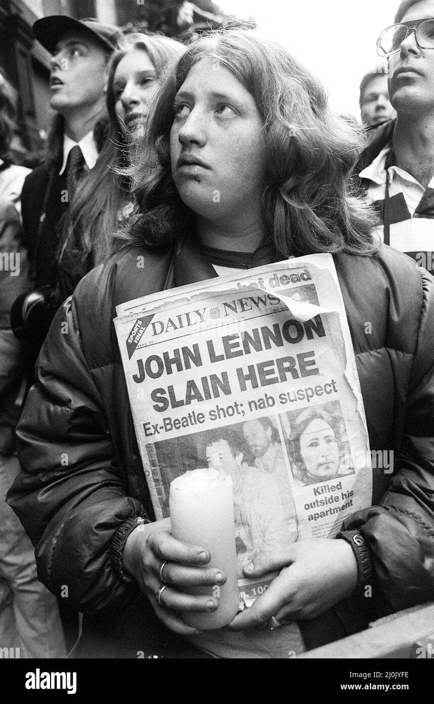 I fan di John Lennon si riuniscono per pagare gli ultimi rispetti fuori dagli appartamenti Dakota a New York, il luogo in cui l'ex Beatle è stato ucciso da Mark Chapman. 9th dicembre 1980. Foto Stock