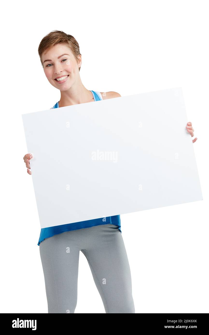 Ive ha ottenuto alcune buone notizie. Studio girato di una giovane donna attraente che tiene in mano un cartello vuoto. Foto Stock