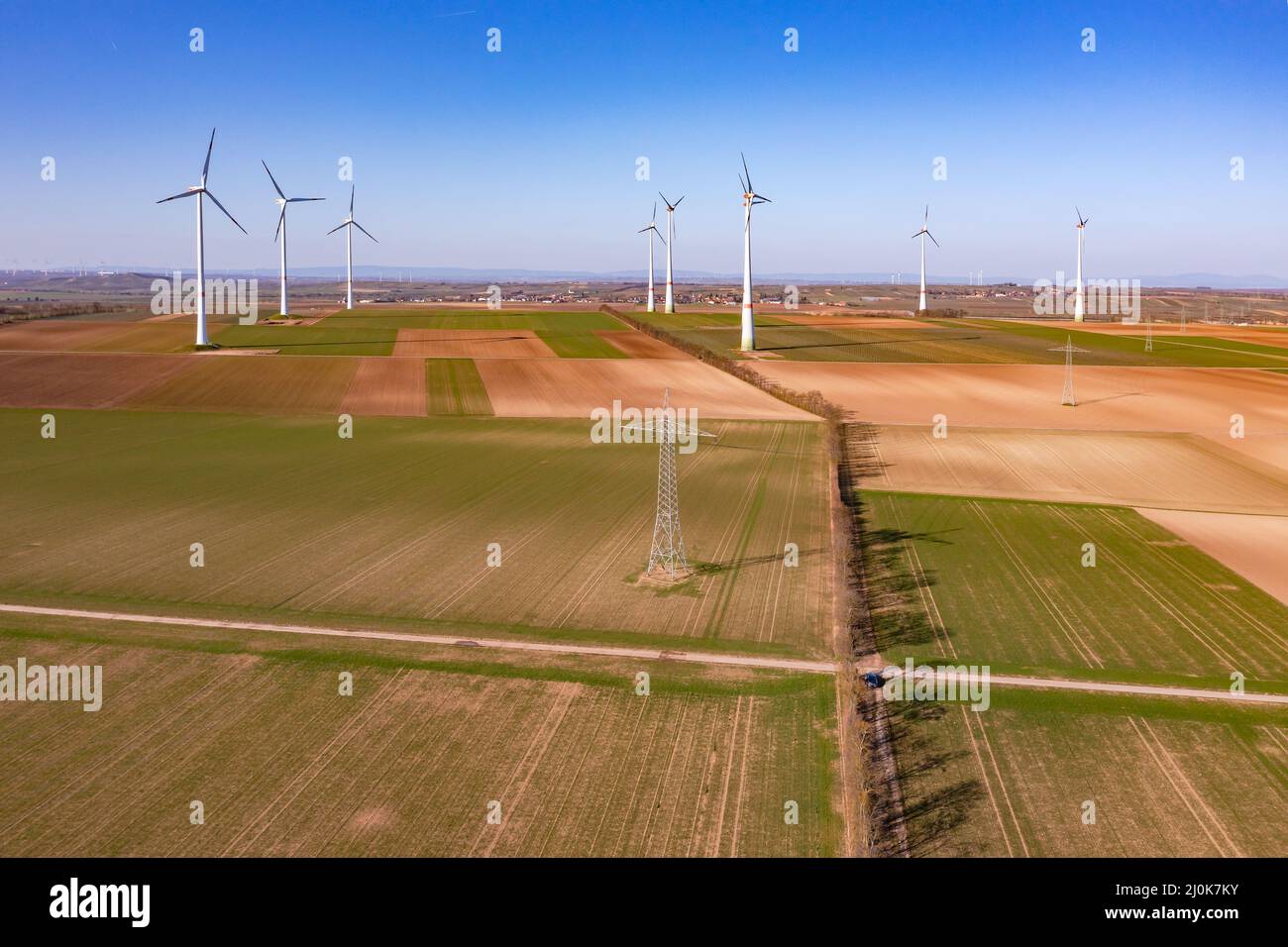 Un'area rurale con un parco eolico e tralicci di elettricità per la transizione energetica in Germania dal punto di vista dei droni Foto Stock