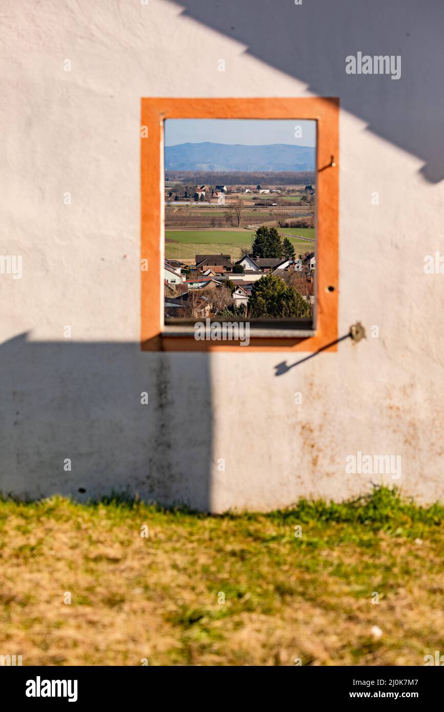 Un muro con una finestra si erge liberamente in natura e crea una vista attraverso Foto Stock