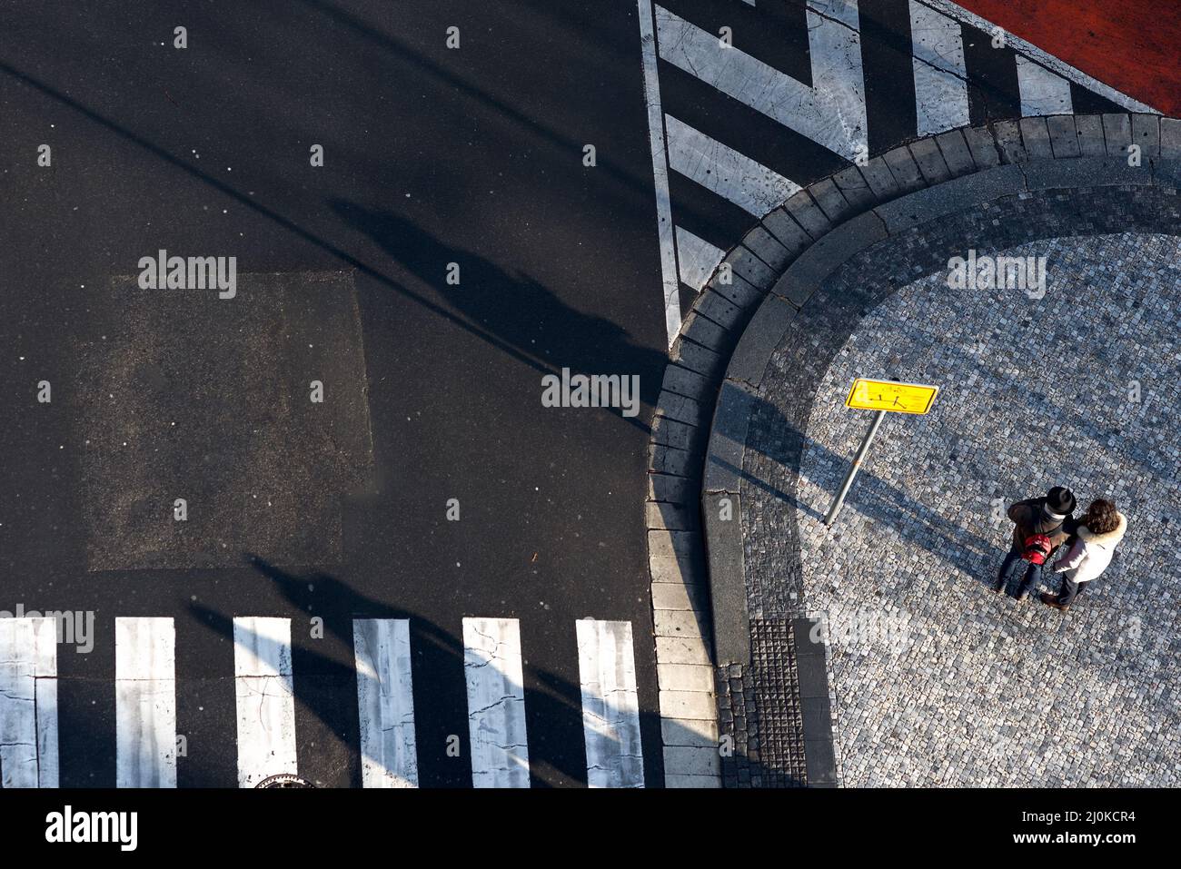 Due persone con un cartello che trovano la loro strada in una città. Vista ad angolo alto Foto Stock