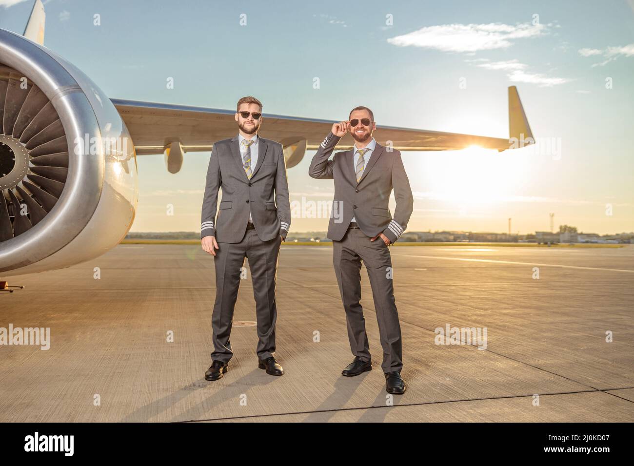 Piloti di aeromobili in piedi vicino al motore di aeroplano in campo aereo Foto Stock