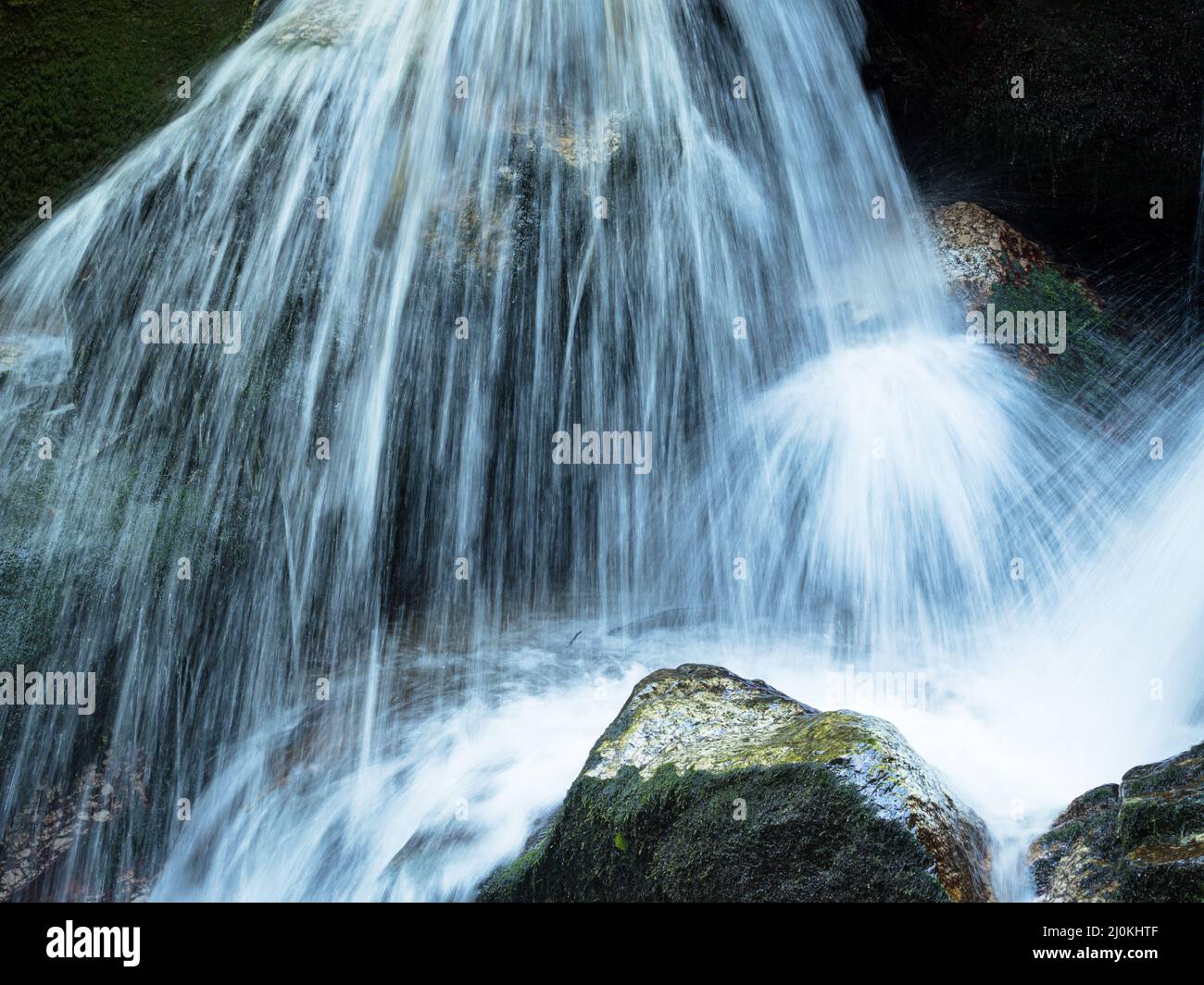 Cascata a lunga esposizione su rocce marroni e verdi a Bad Kreuzen Austria Foto Stock