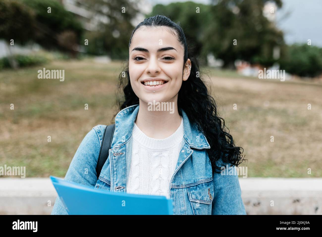 Giovane studentessa caucasica sorridente alla macchina fotografica Foto Stock