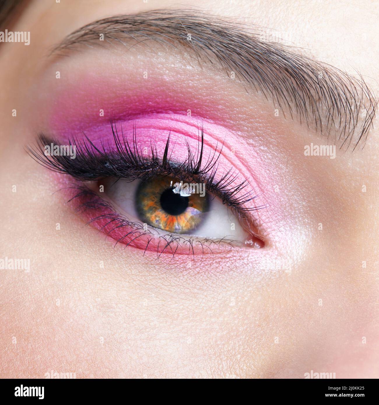 Macro closeup dell'occhio umano femminile con ombre degli occhi rosa Foto Stock