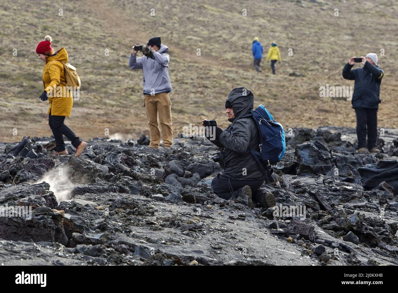 Persone sul paesaggio di lava vulcanica di recente eruzione, Fagradersfjall, penisola di Reykjanes, Islanda, EUR Foto Stock