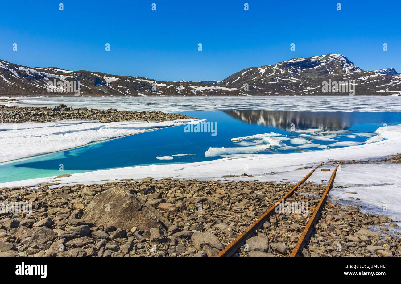 Vecchie rotaie conducono in acqua del lago congelato Vavatn Hemsedal. Foto Stock