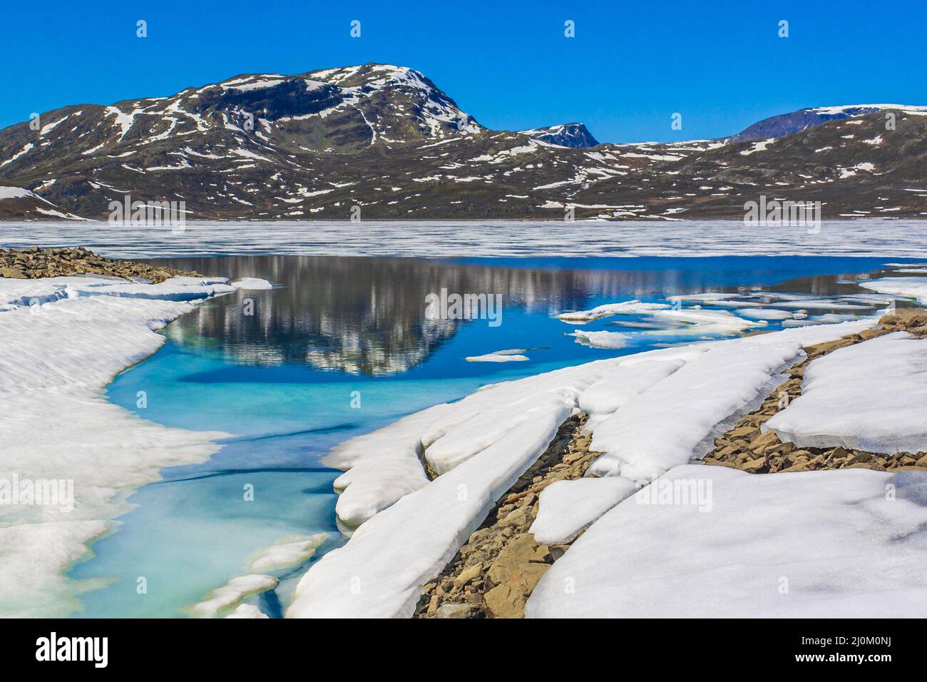 Ghiacciato lago turchese Vavatn panorama in estate paesaggio Hemsedal Norvegia. Foto Stock