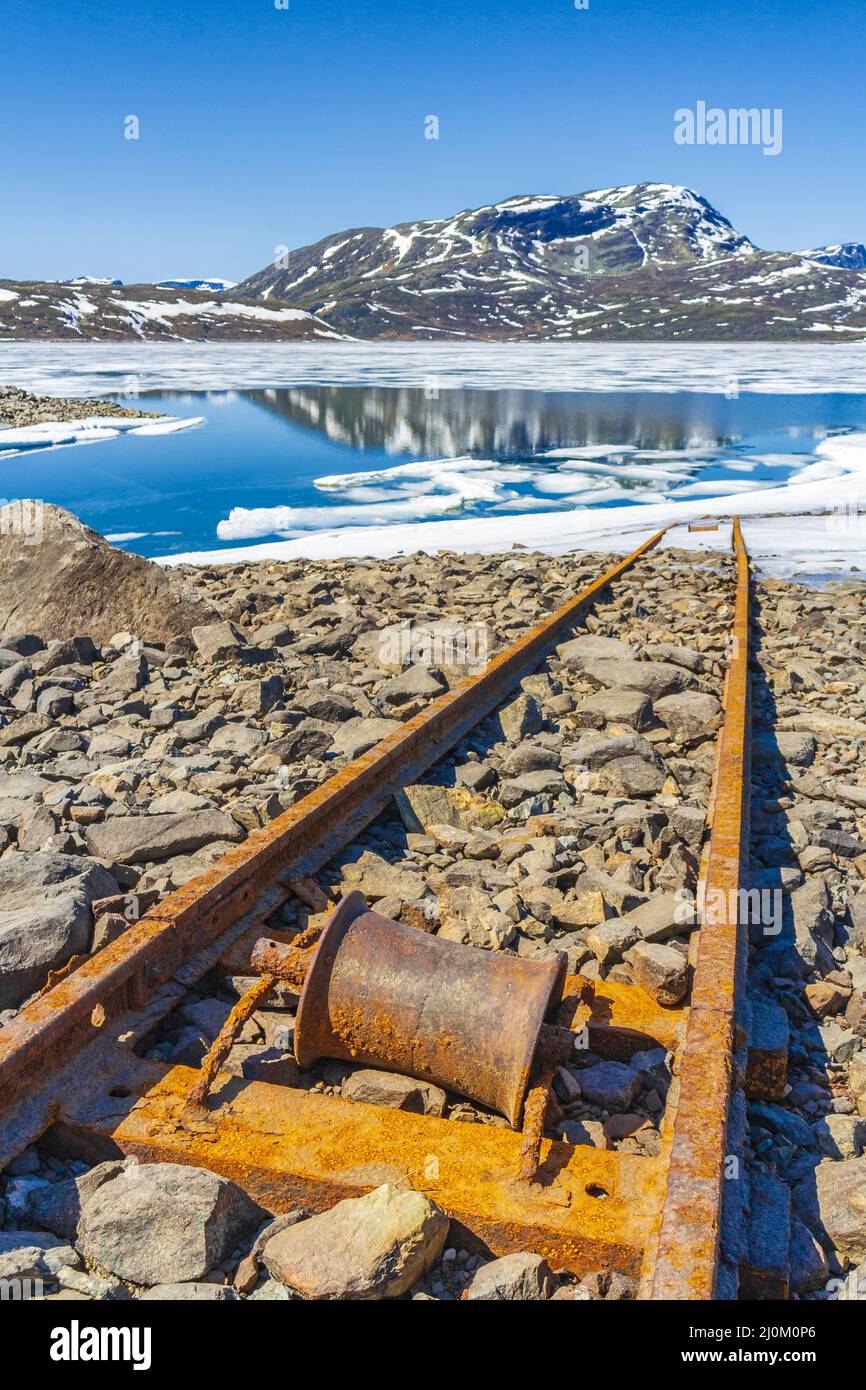 Vecchie rotaie conducono in acqua del lago congelato Vavatn Hemsedal. Foto Stock