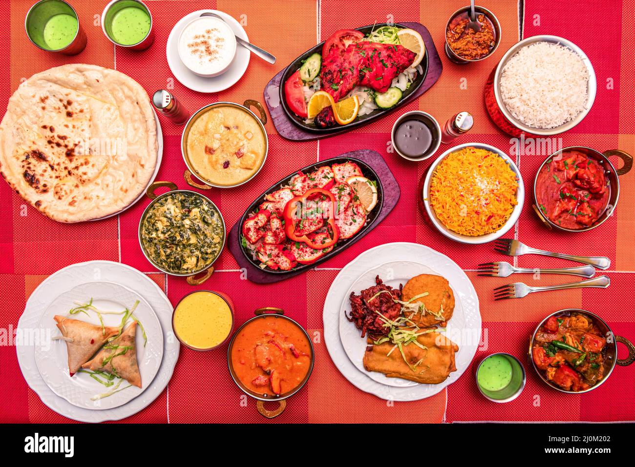 Piatti indiani colorati con vari tipi di curry, naan, paneer palak, agnello, pollo tandoori, tikka masala, antipasti, riso basmati, falafel Foto Stock