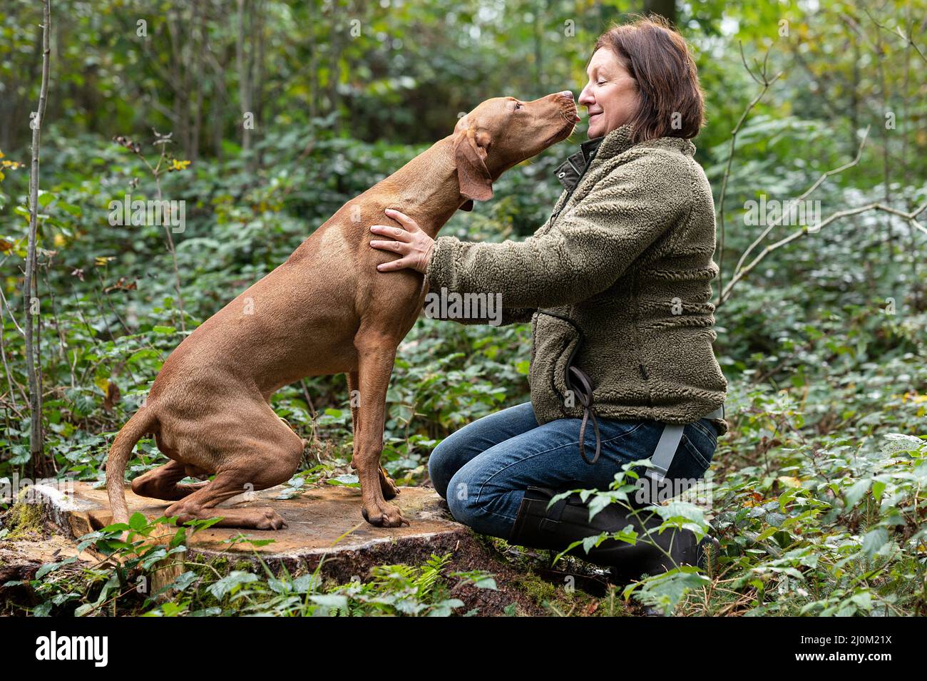Donna con il suo cane da caccia Foto Stock