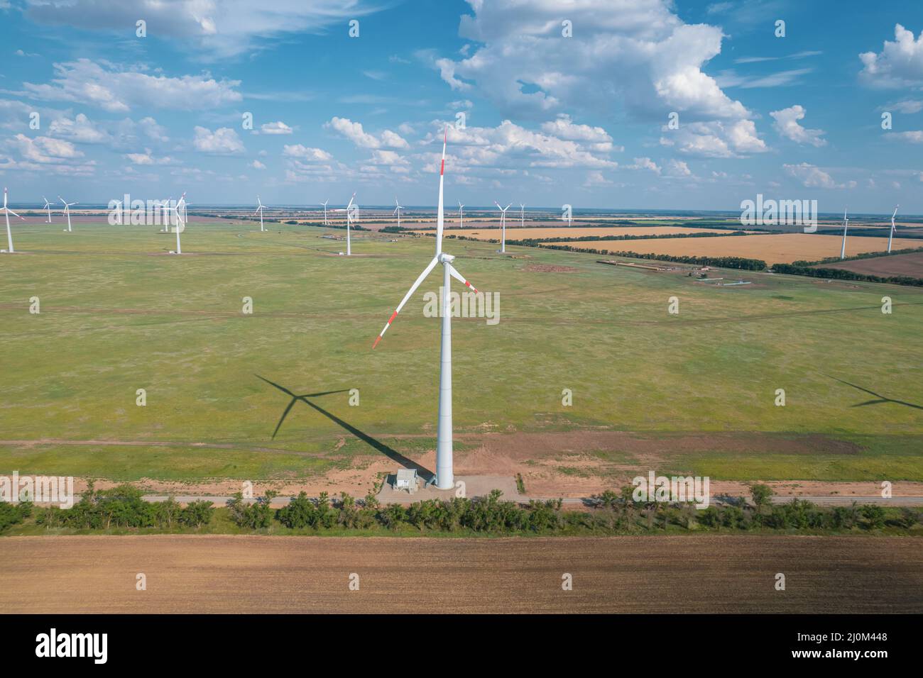 Vista aerea della turbina eolica è una popolare fonte di energia sostenibile e rinnovabile su un bel cielo nuvoloso. Turbine eoliche Foto Stock