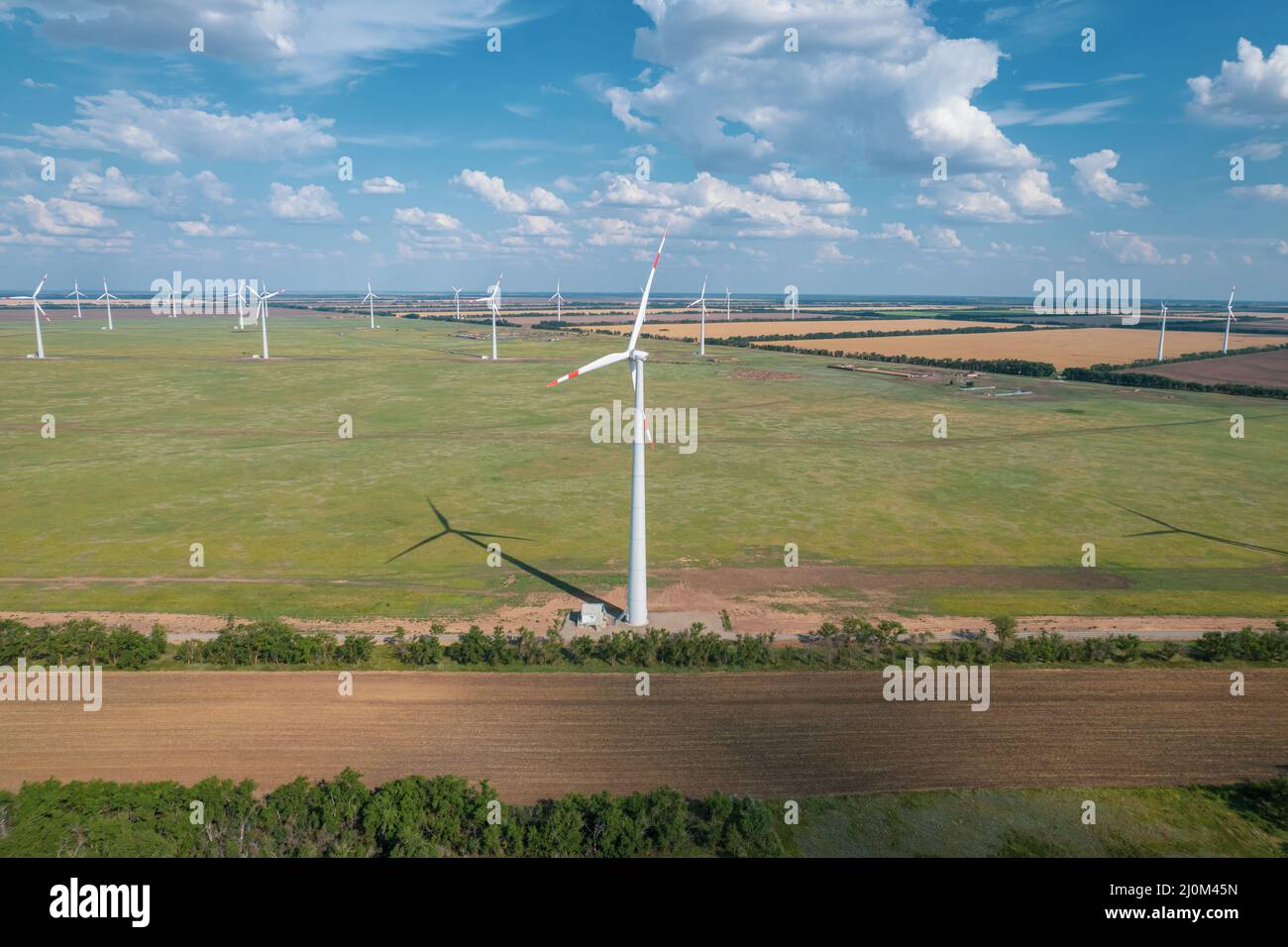 Vista aerea della turbina eolica è una popolare fonte di energia sostenibile e rinnovabile su un bel cielo nuvoloso. Turbine eoliche Foto Stock