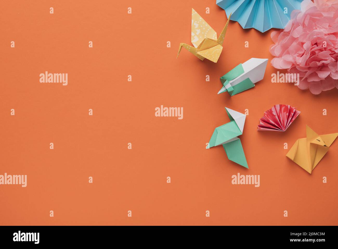 Vista ad angolo alto origami carta arte artigianale superficie arancione Foto Stock