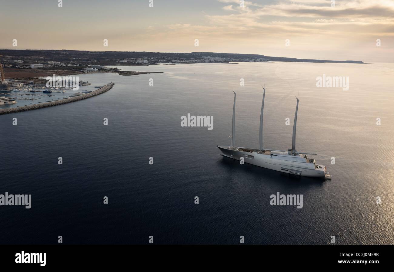 Vista aerea con droni di un lussuoso yacht ormeggiato al di fuori di un porto all'alba Foto Stock