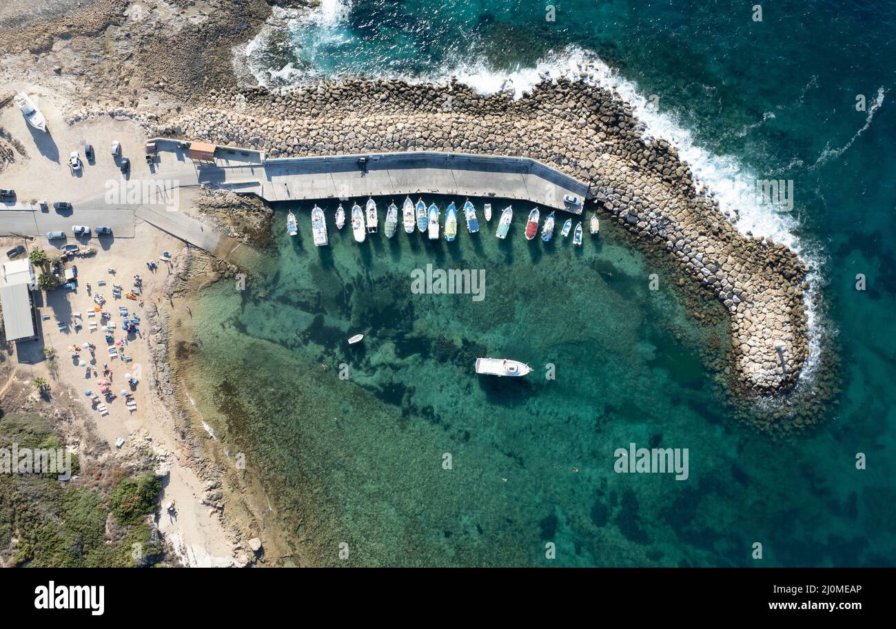 Vista aerea del drone delle barche da pesca ormeggiate al porto. Ormeggiate al frangiflutti. Foto Stock