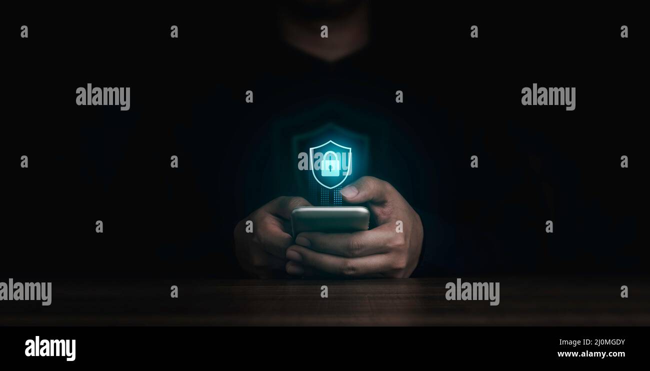 Il pulsante di blocco dello schermo e le icone delle informazioni personali vengono visualizzate mentre il dito dell'uomo tocca lo smartphone su sfondo scuro. Sicurezza informatica, dati Foto Stock