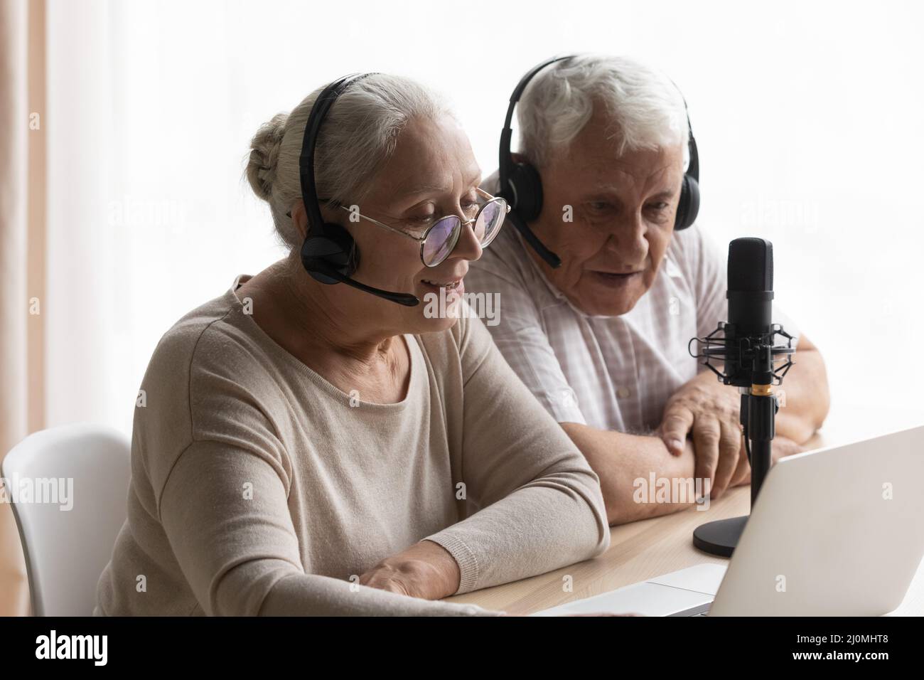 Le coppie anziano conducono la conversazione in streaming online utilizzando il computer e il microfono Foto Stock