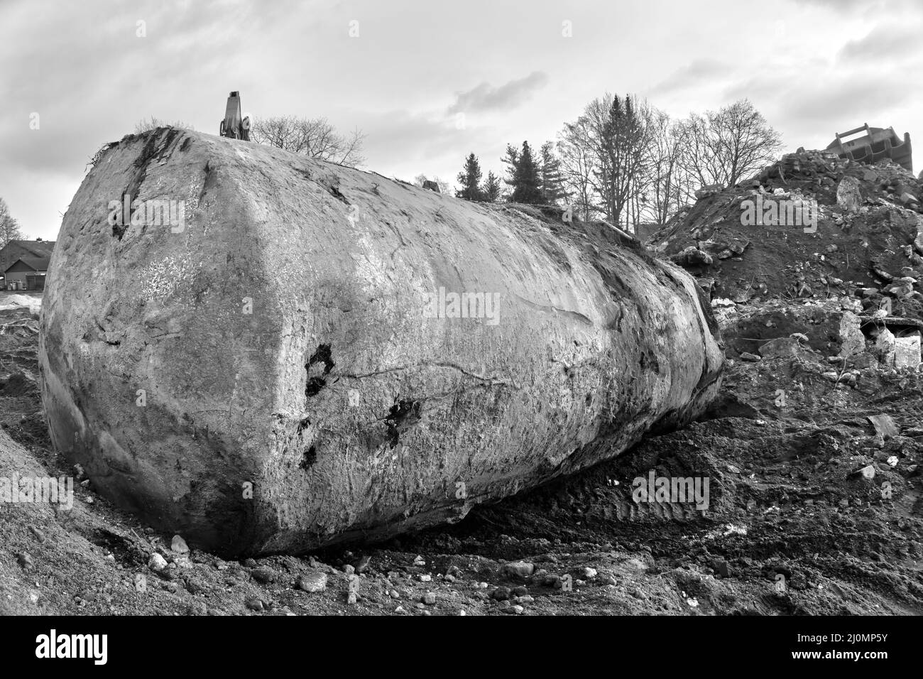 Serbatoio terra scavato per olio e benzina vicino a una collina con detriti da costruzione e terreno scavato Foto Stock