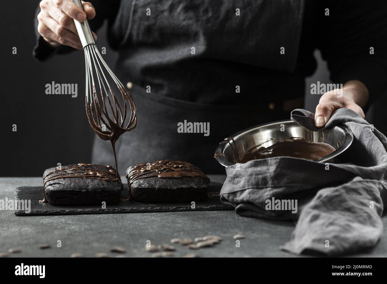 Vista frontale dello chef pasticceria che prepara la torta con il cioccolato Foto Stock