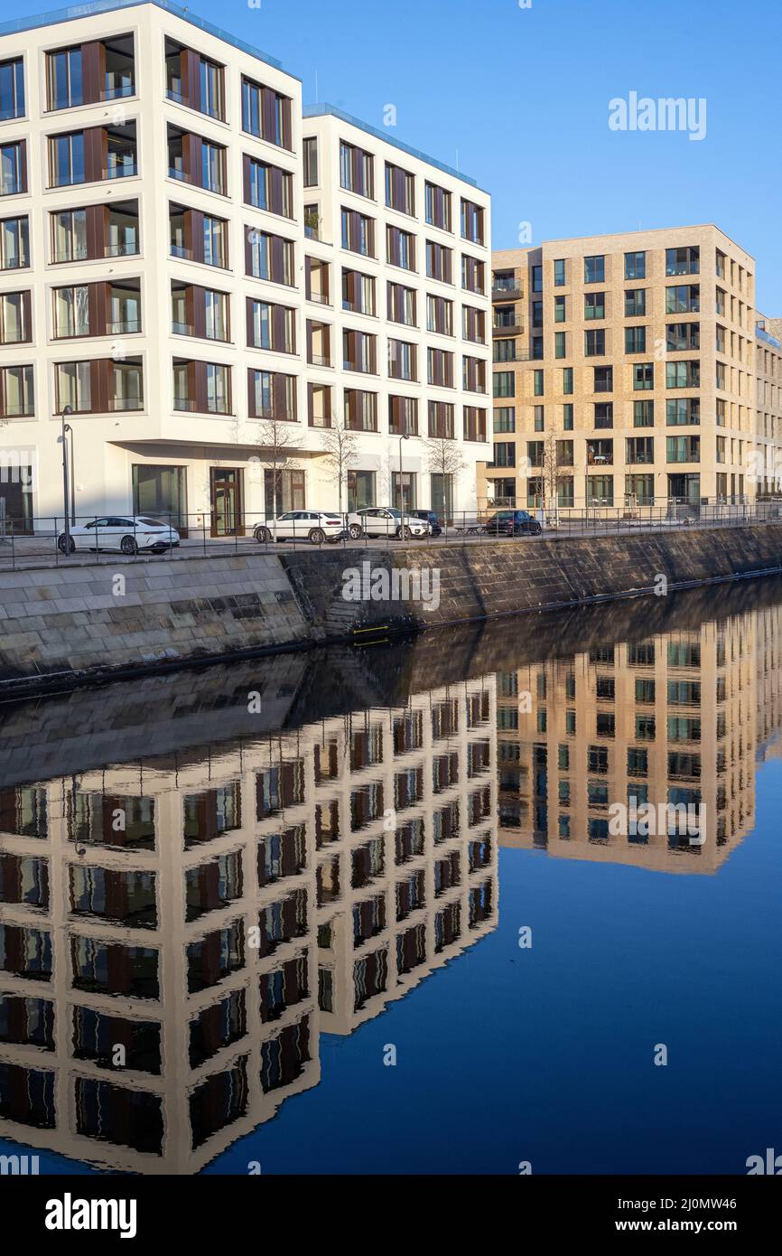 Nuovi appartamenti si riflettono in un piccolo canale visto a Berlino, Germania Foto Stock