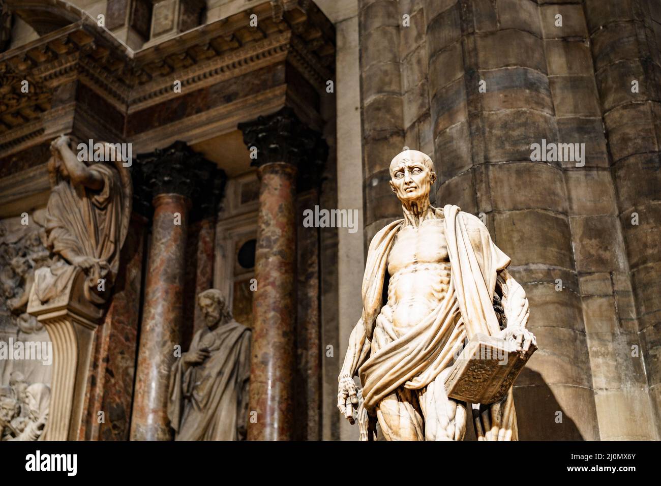 Statua di San Bartolomeo con un libro in mano nel Duomo. Italia, Milano Foto Stock