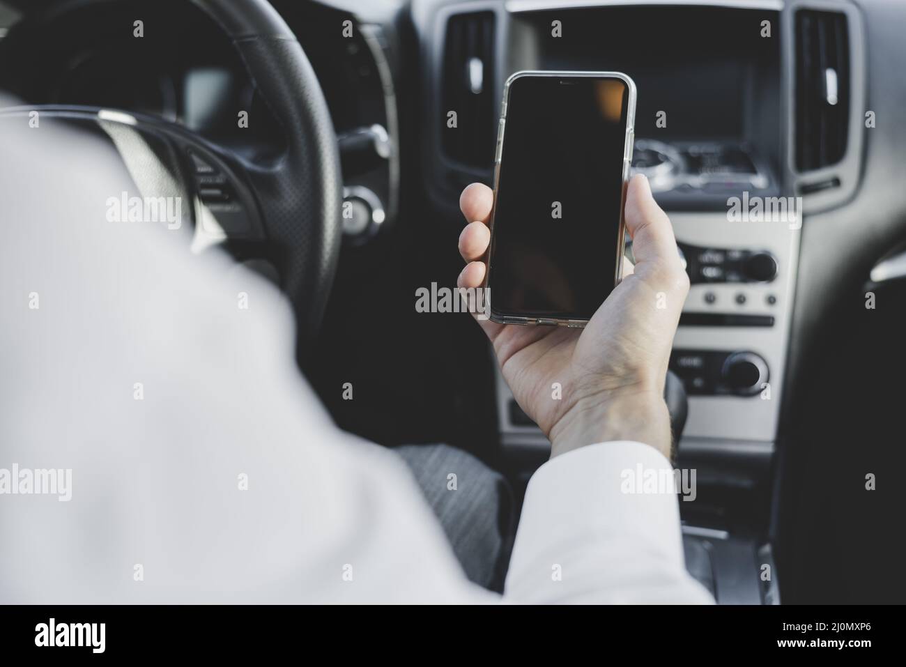 Primo piano mano uomo che tiene il telefono cellulare con schermo vuoto auto Foto Stock
