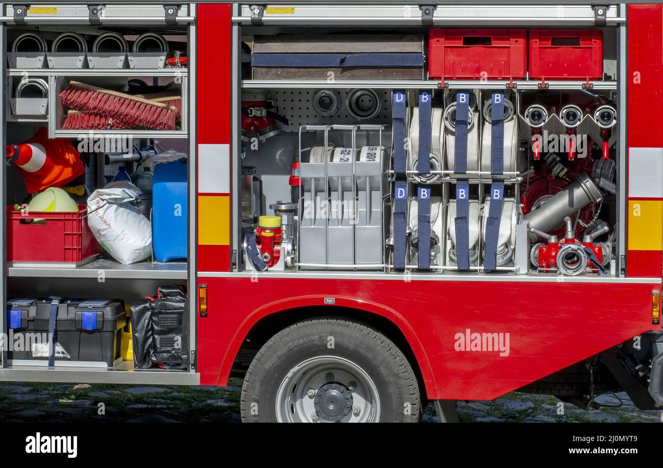 La vista laterale dell'attrezzatura all'interno di un motore antincendio. Camion antincendio con botole aperte che mostrano l'attrezzatura di soccorso. Foto Stock