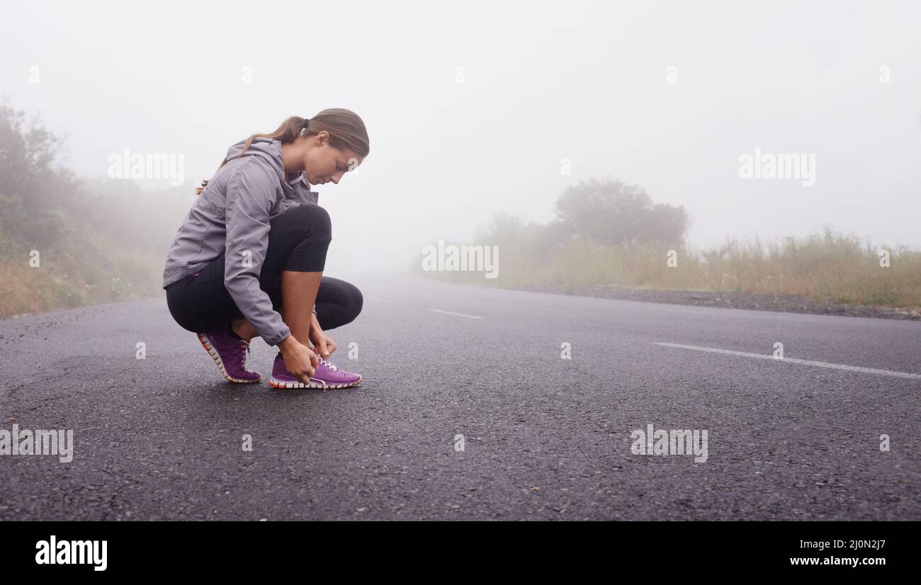 Im pronto a colpire la strada. Scatto di una giovane donna che si prepara per una corsa. Foto Stock