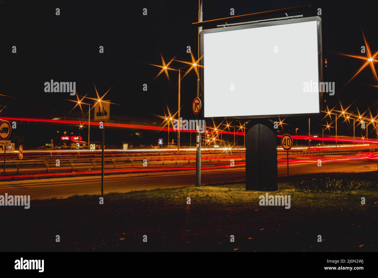 Cartellone pubblicitario vuoto con luci di traffico offuscate notte Foto Stock