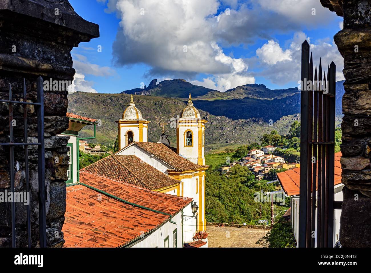 Bella chiesa storica nella città di Ouro Preto visto tra antichi portali in pietra Foto Stock