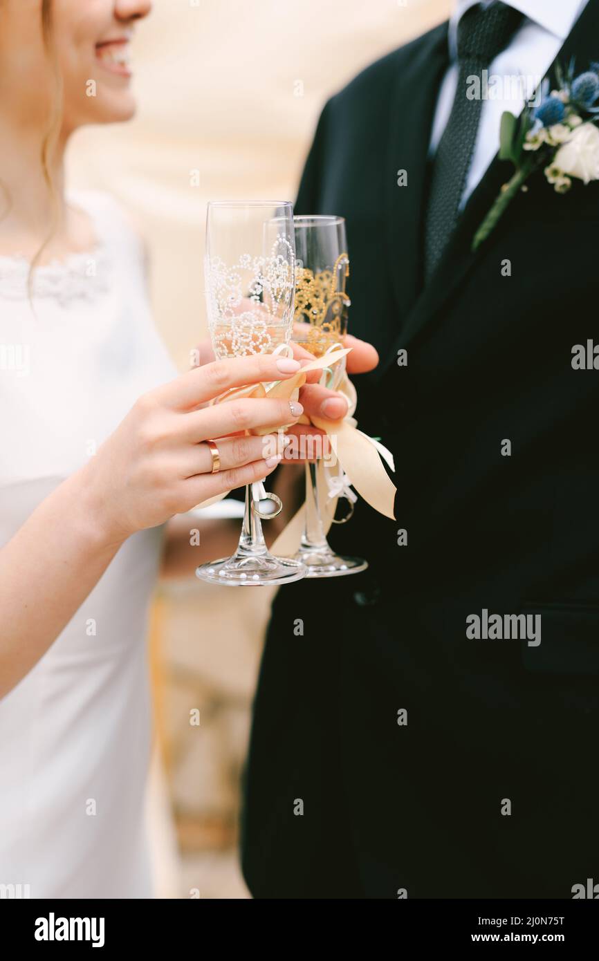 Bride e sposo clink bicchieri di champagne. Primo piano Foto Stock