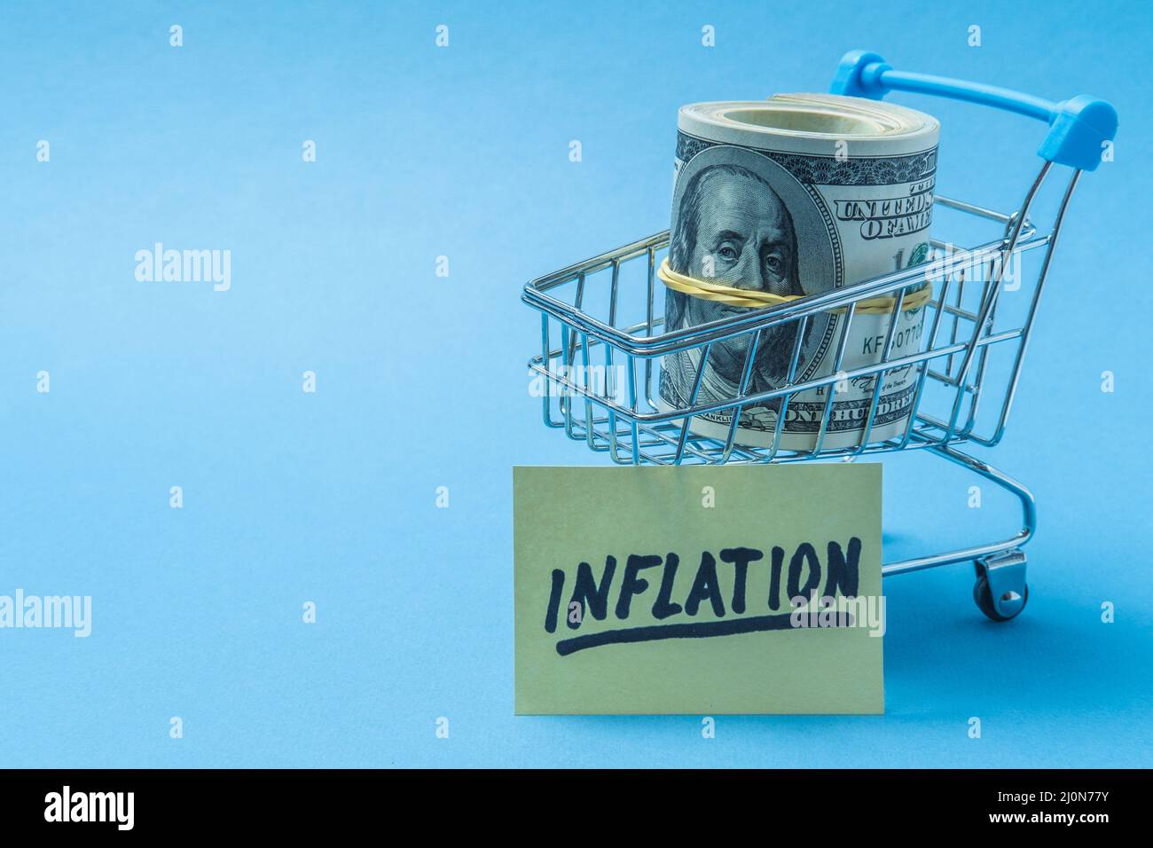 Dollari sono in un cestino di alimentari, con un poster su cui l'iscrizione inflazione. Foto Stock