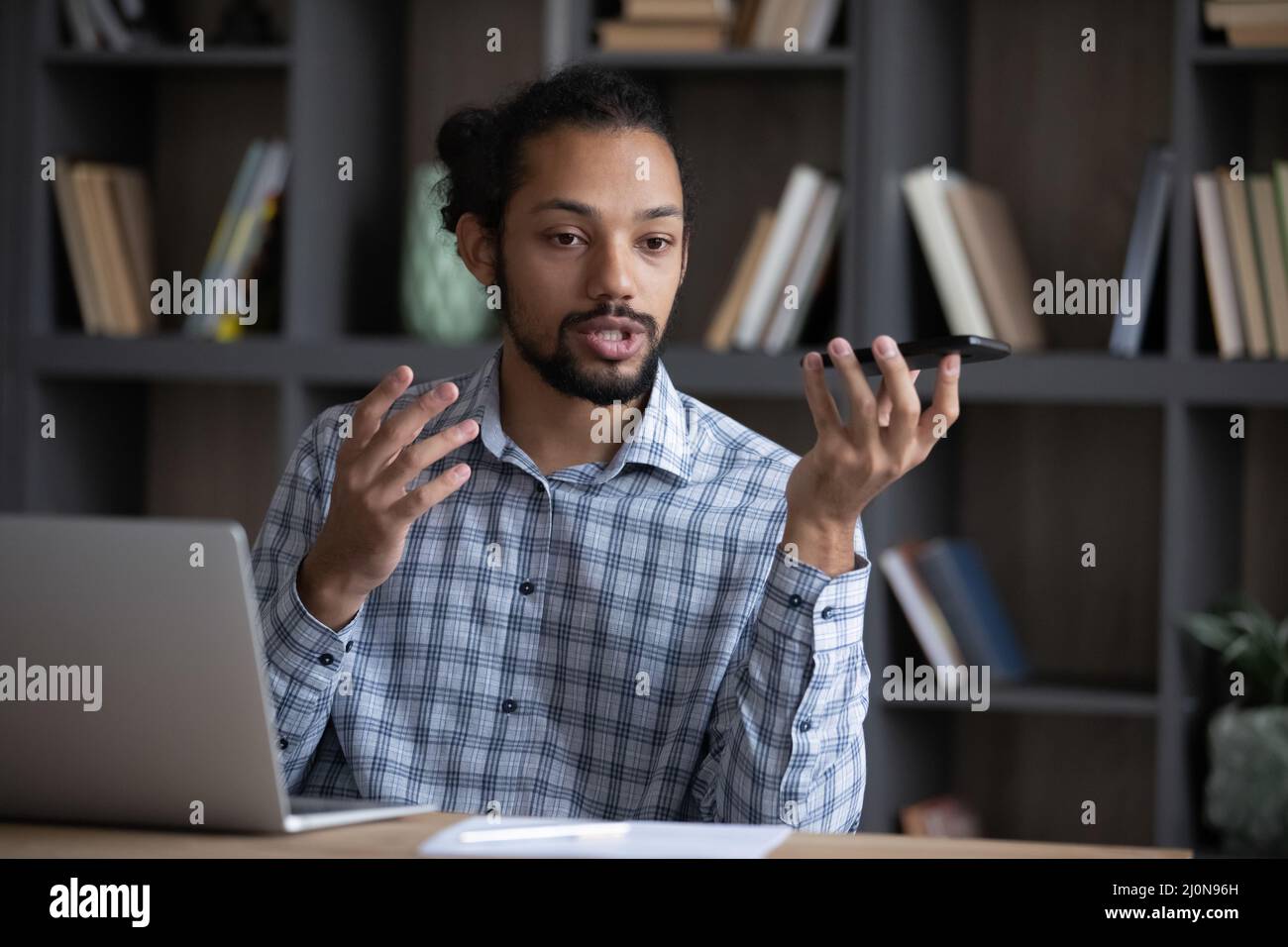 Serio uomo freelance afroamericano che dà il comando vocale Foto Stock