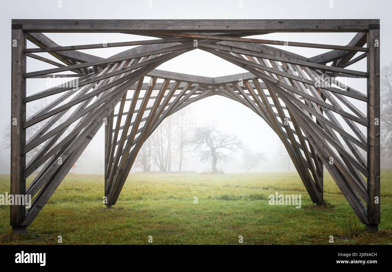 Alberi antichi in nebbia con struttura in legno di fronte Foto Stock