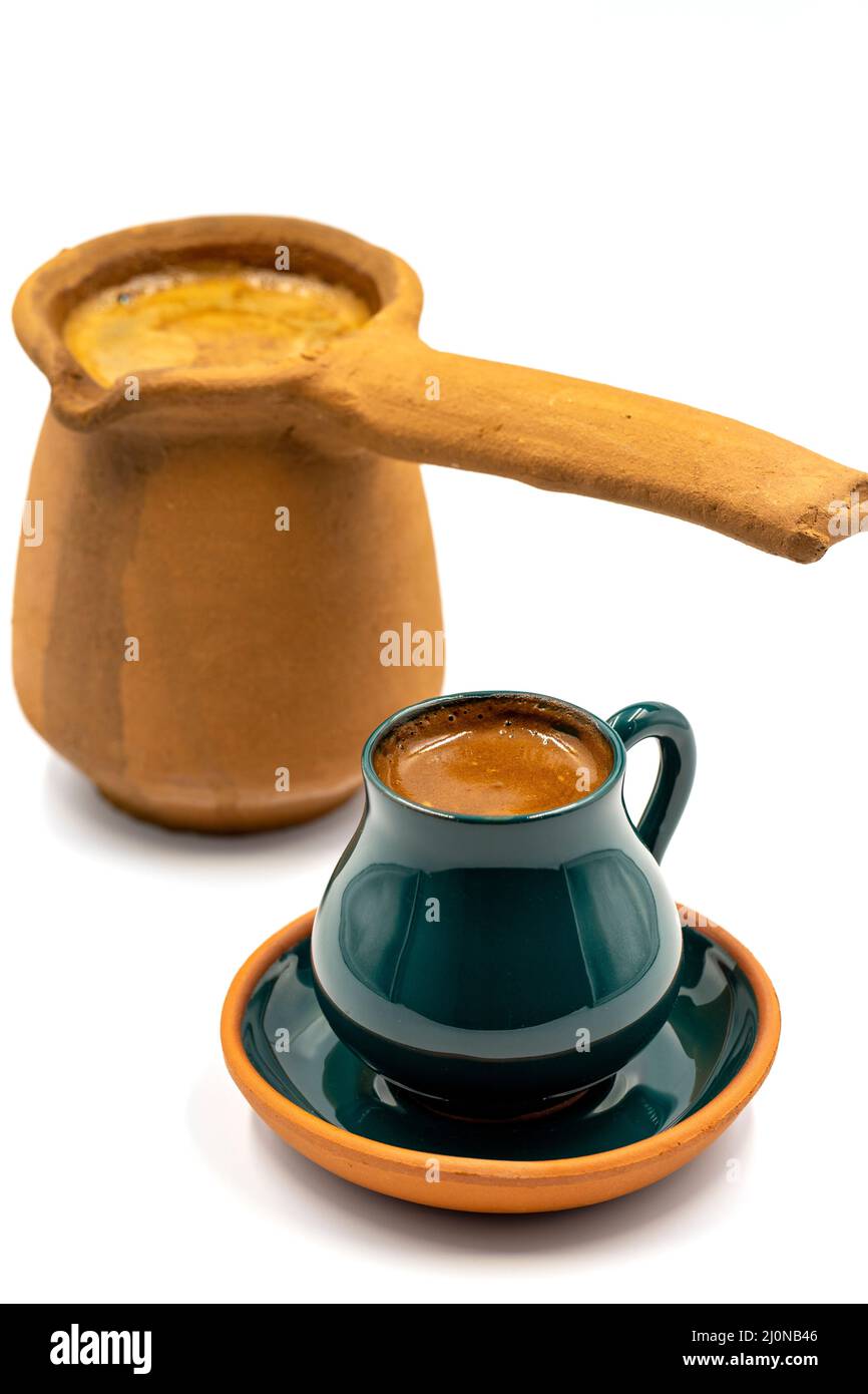 Caffè turco su sfondo bianco. Tazza rustica e caffettiera terrina. Foto Stock