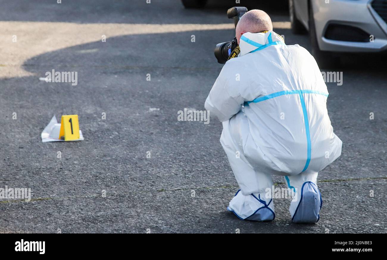 Ufficiali forensi del Garda lavorano sulla scena a Finglas, a nord di Dublino, dove una donna nel suo 30s è morta in un incidente di tiro il sabato sera. Data foto: Domenica 20 marzo 2022. Foto Stock