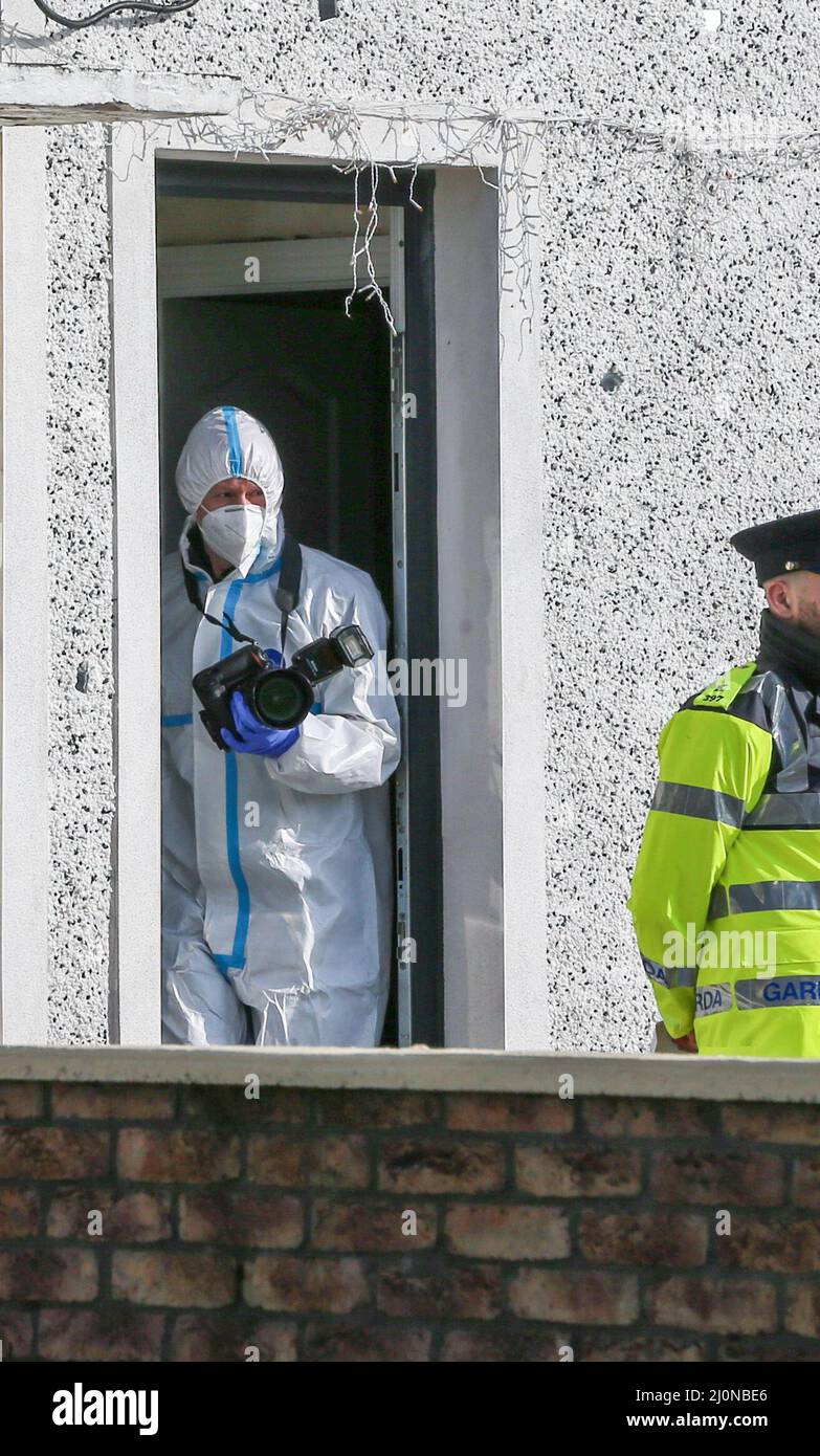 Ufficiali forensi del Garda lavorano sulla scena a Finglas, a nord di Dublino, dove una donna nel suo 30s è morta in un incidente di tiro il sabato sera. Data foto: Domenica 20 marzo 2022. Foto Stock