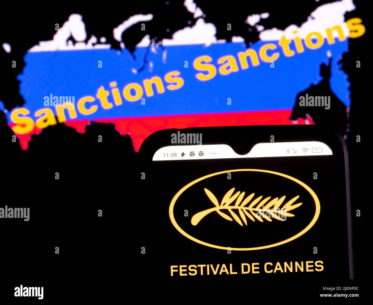 In questa foto, il logo Festival de Cannes viene visualizzato su uno schermo dello smartphone con una bandiera della Russia sotto forma di una mappa del paese con l'iscrizione di sanzioni Foto Stock