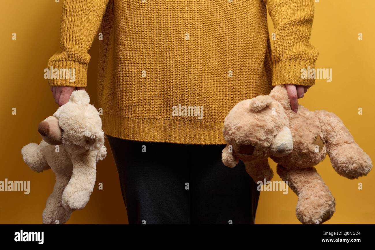 Donna in maglia arancione con carino orsacchiotto marrone. Il concetto di solitudine e tristezza, depressione Foto Stock