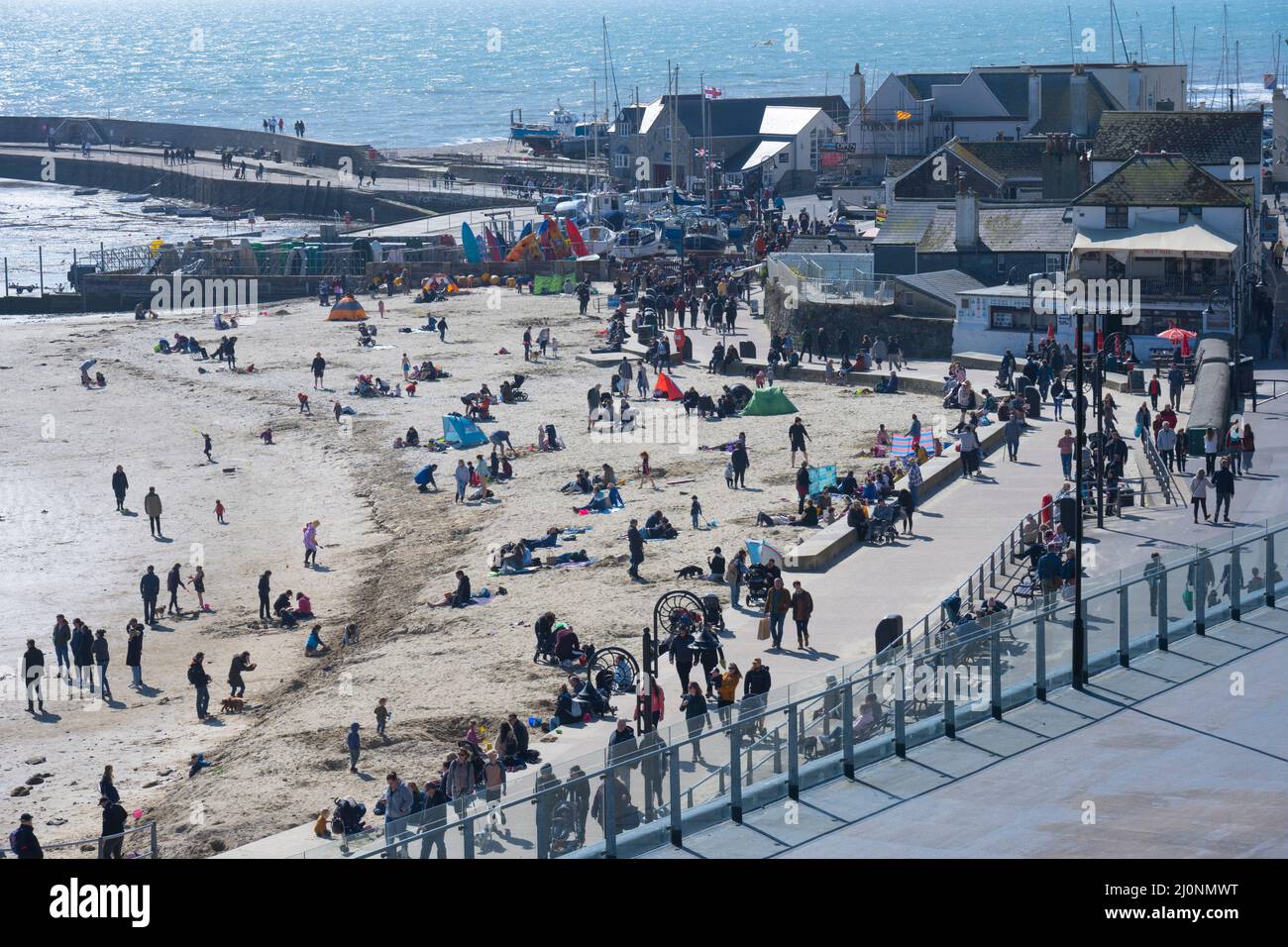 Lyme Regis, Dorset, Regno Unito. 20th Mar 2022. UK Meteo: I visitatori e la gente del posto si affollano alla spiaggia per assorbire il sole caldo e cielo blu limpido alla stazione balneare di Lyme Regis come la mini marzo caldo onda continua. Il tempo soleggiato è impostato per durare bene nella prossima settimana come alta pressione domina. Credit: Celia McMahon/Alamy Live News Foto Stock