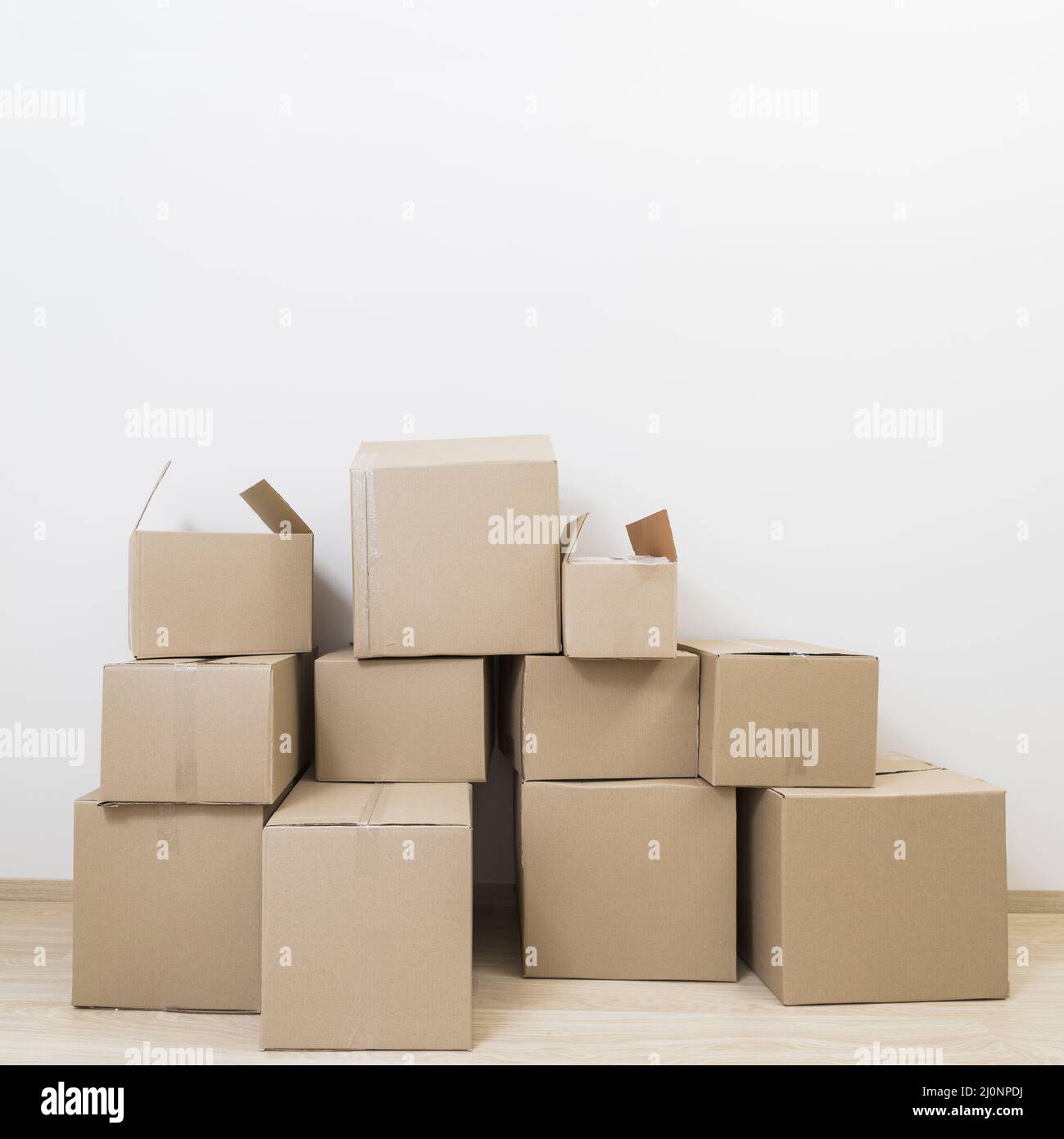 scatole di cartone mobili impilate contro la parete bianca