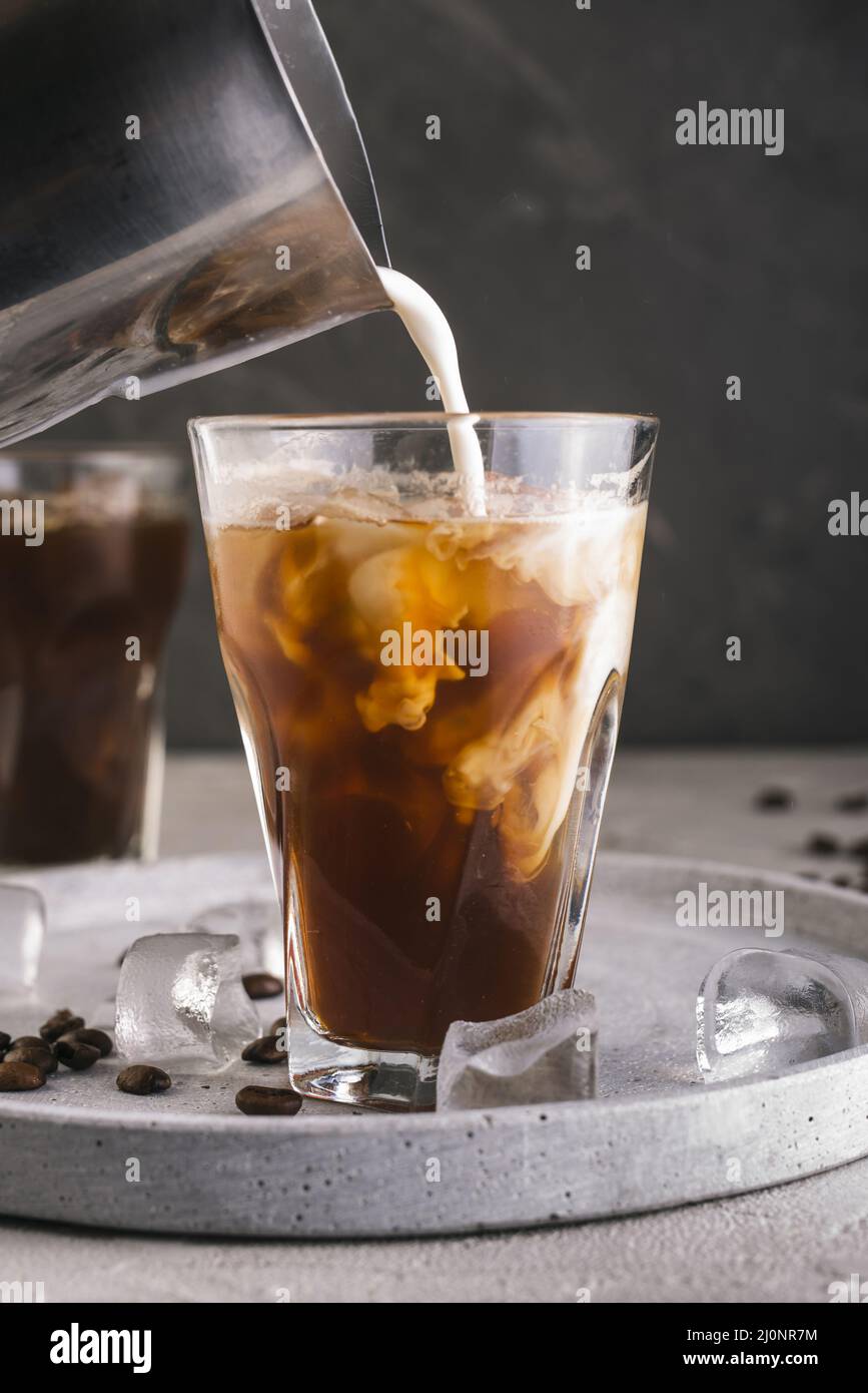 Versare il latte in un bicchiere con il caffè. Alta qualità e risoluzione bellissimo concetto di foto Foto Stock