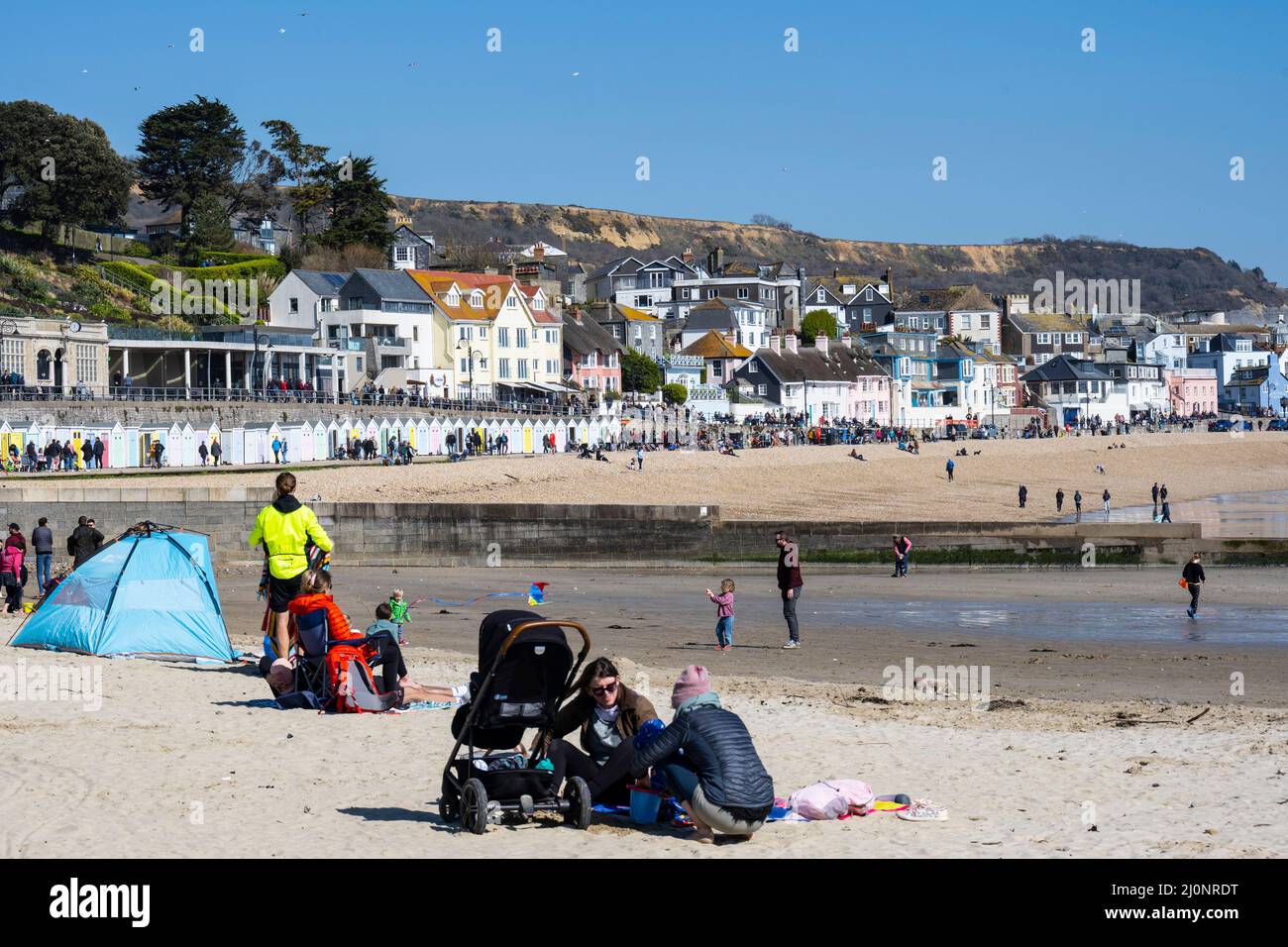 Lyme Regis, Dorset, Regno Unito. 20th Mar 2022. UK Meteo: I visitatori e la gente del posto si affollano alla spiaggia per assorbire il sole caldo e cielo blu limpido alla stazione balneare di Lyme Regis come la mini marzo caldo onda continua. Il tempo soleggiato è impostato per durare bene nella prossima settimana come alta pressione domina. Credit: Celia McMahon/Alamy Live News Foto Stock