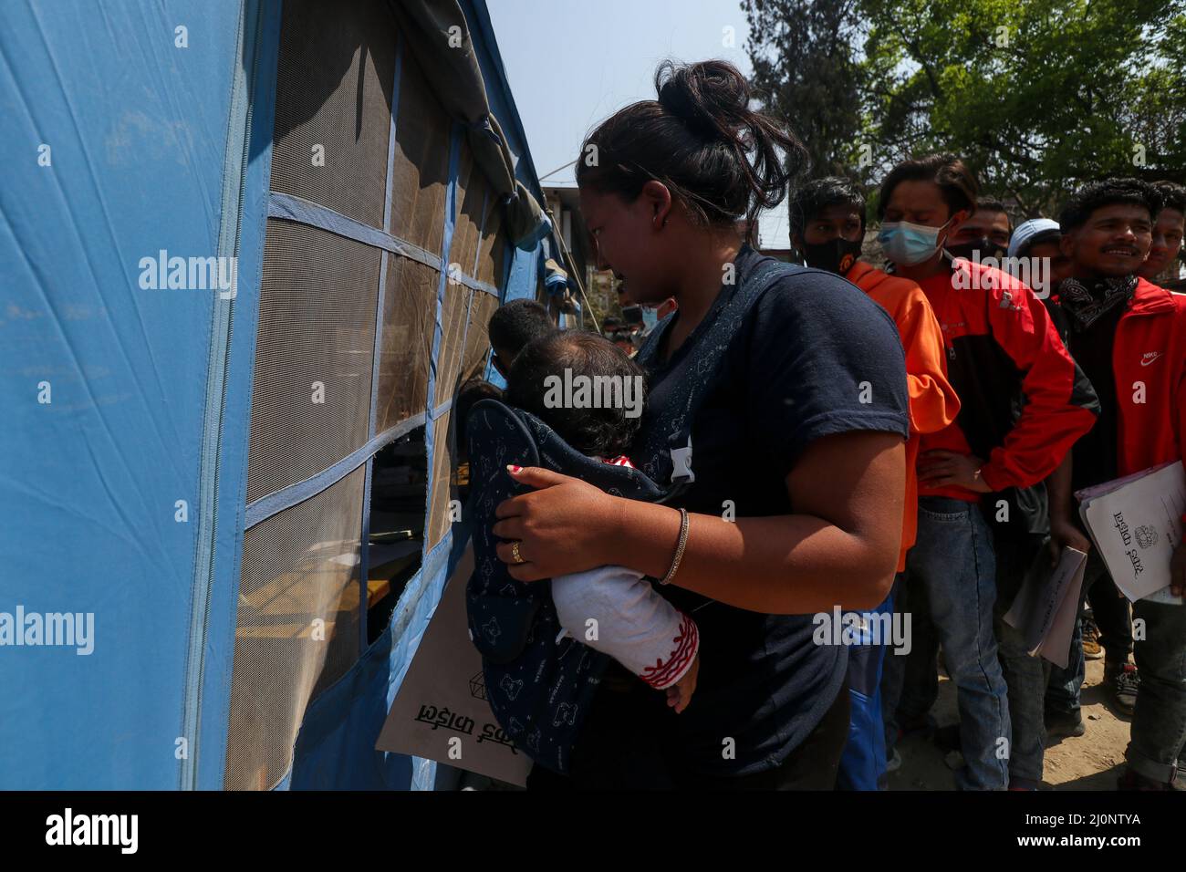 Kathmandu, NE, Nepal. 20th Mar 2022. Sapan Taman, Gurung, 21 anni, è in linea con il suo bambino di un anno per presentare la richiesta di polizia temporanea (polizia di Myadi) per le prossime elezioni locali a Kathmandu, Nepal il 20 marzo 2022. 'Anche se mio marito lavora in un negozio di mobili, il nostro status finanziario non è così forte. Così sono venuto qui per presentare la richiesta della polizia temporanea nella speranza di riempire qualche cosa necessaria, '' dice. (Credit Image: © Aryan Dhimal/ZUMA Press Wire) Foto Stock