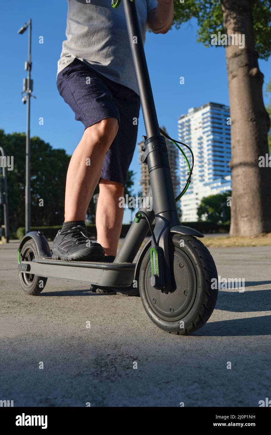 Uomo irriconoscibile con il suo scooter elettrico in città una mattinata di  sole. Concetti di sostenibilità, modernità, energia pulita e mobilità verde  Foto stock - Alamy
