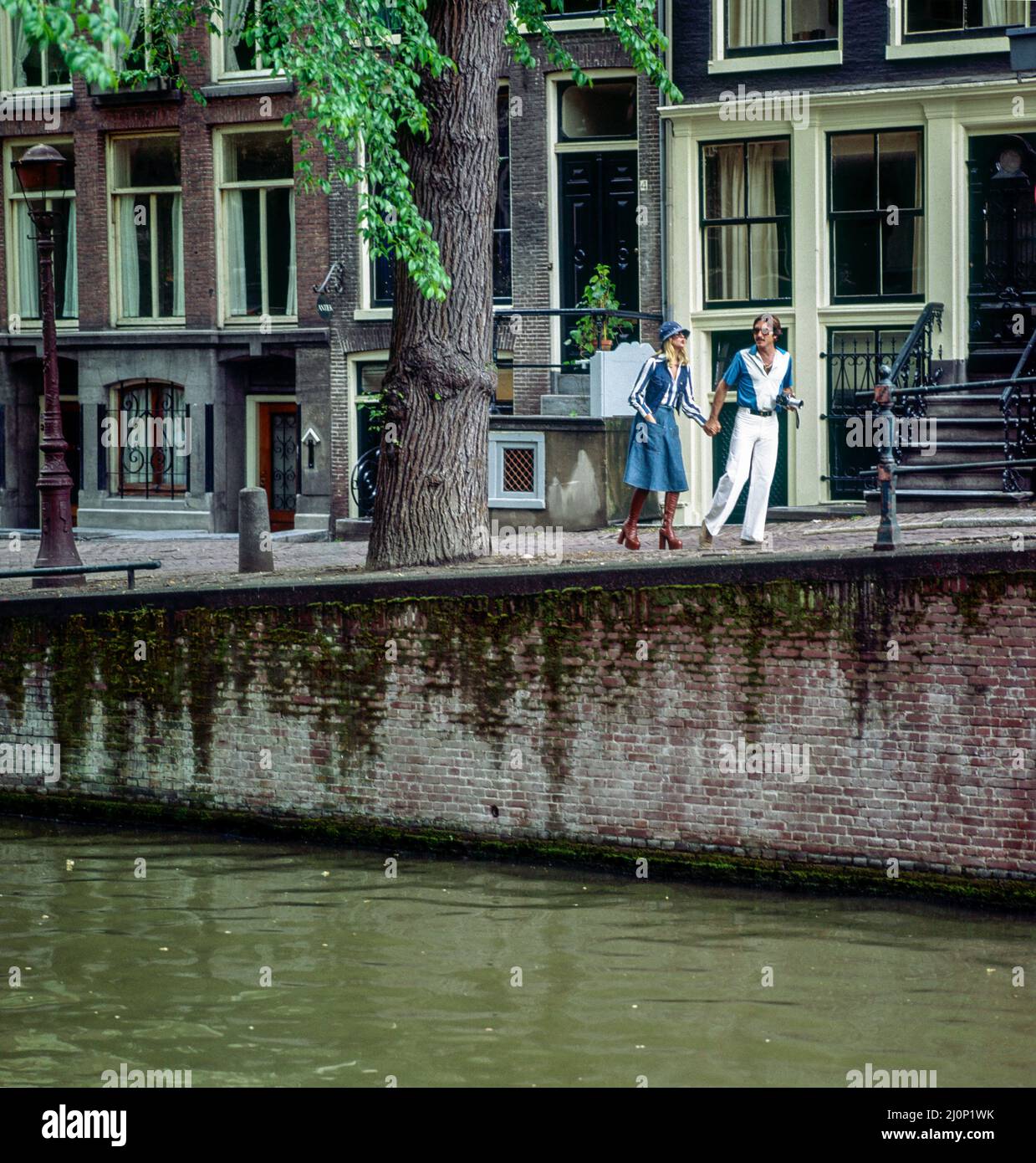 Vintage Amsterdam 1970s, giovane coppia elegante passeggiando accanto al canale, case, Olanda, Paesi Bassi, Europa, Foto Stock