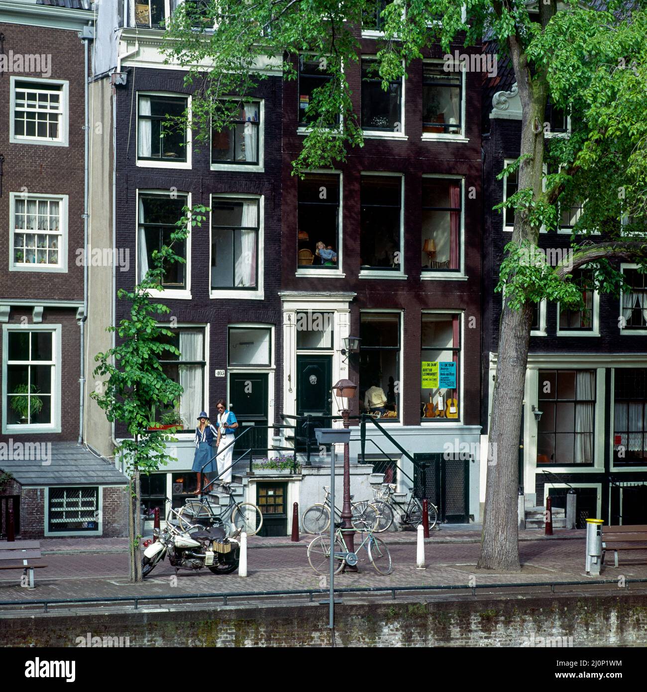 Vintage Amsterdam 1970s, elegante giovane coppia passeggiando, case accanto al canale, Olanda, Paesi Bassi, Europa, Foto Stock