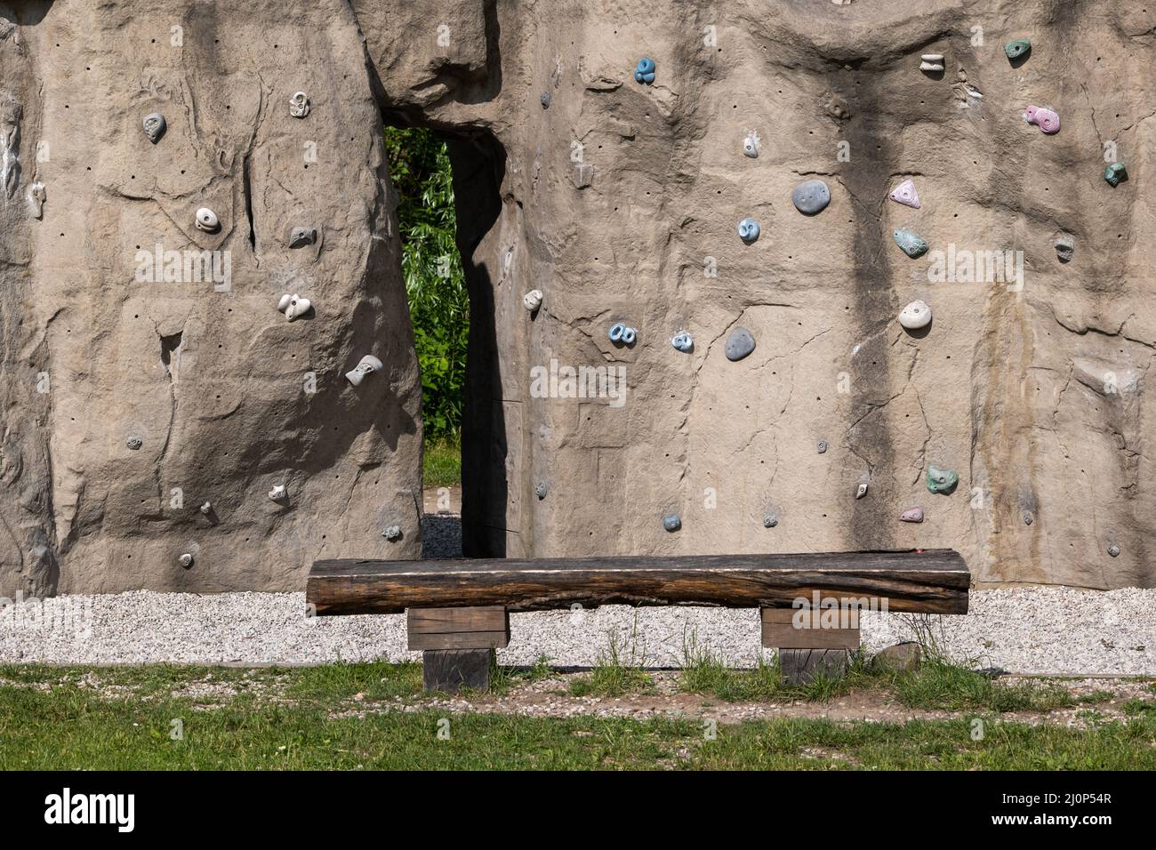 Parete di arrampicata in parco urbano, roccia artificiale con prese e impugnature. Foto Stock